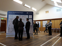 Members of the public with SSEN Transmission staff in front of a large map.