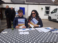 SSEN Transmission employees at a table with booklets titled "Orkney Infrastructure Project".