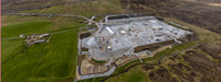 An aerial view of a substation under construction in a rural area.