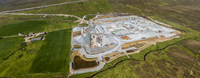 An aerial view of a substation under construction in a rural area.