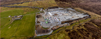 An aerial view of a substation under construction in a rural area.