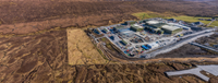 An aerial view of a substation under construction in a rural area.