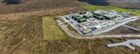 An aerial view of a substation under construction in a rural area.