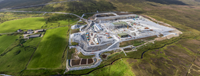 An aerial view of a substation under construction in a rural area.