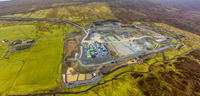 An aerial view of a substation under construction in a rural area.