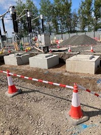 Concrete blocks on a construction site, substation infrastructure nearby.