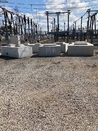 Several concrete cuboids in front of substation infrastructure.