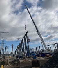 A metal structure suspended from a crane.