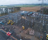 Construction equipment on a substation. A large pile of rubble is prominent.