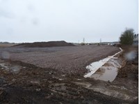 A rough stone surfaced area, a large rock or dirt mound in the distance.