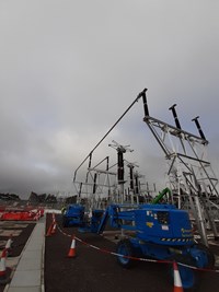 Construction vehicles next to substation infrastructure.