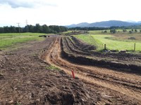 A dirt path dug through a hilly area.