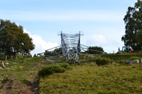 A metal transmission tower laying sideways on the ground.