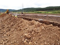 Contractors in a dirt trench.