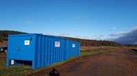 Small, blue, corrugated metal walled buildings.