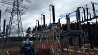 Substation infrastructure in a substation under construction. A construction vehicle and barriers are present surrounding the infrastructure.