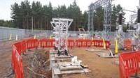 Several concrete structures embedded into an excavated area on a construction site. Substation infrastructure is attached to the top of some of the concrete sections.