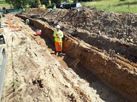 Contractors in PPE in an excavated trench.