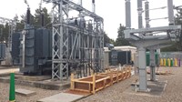 A wooden trough between two sections of substation infrastructure.