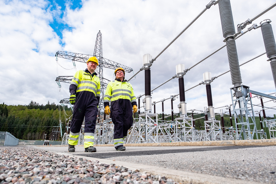 Two workers walking through a site.