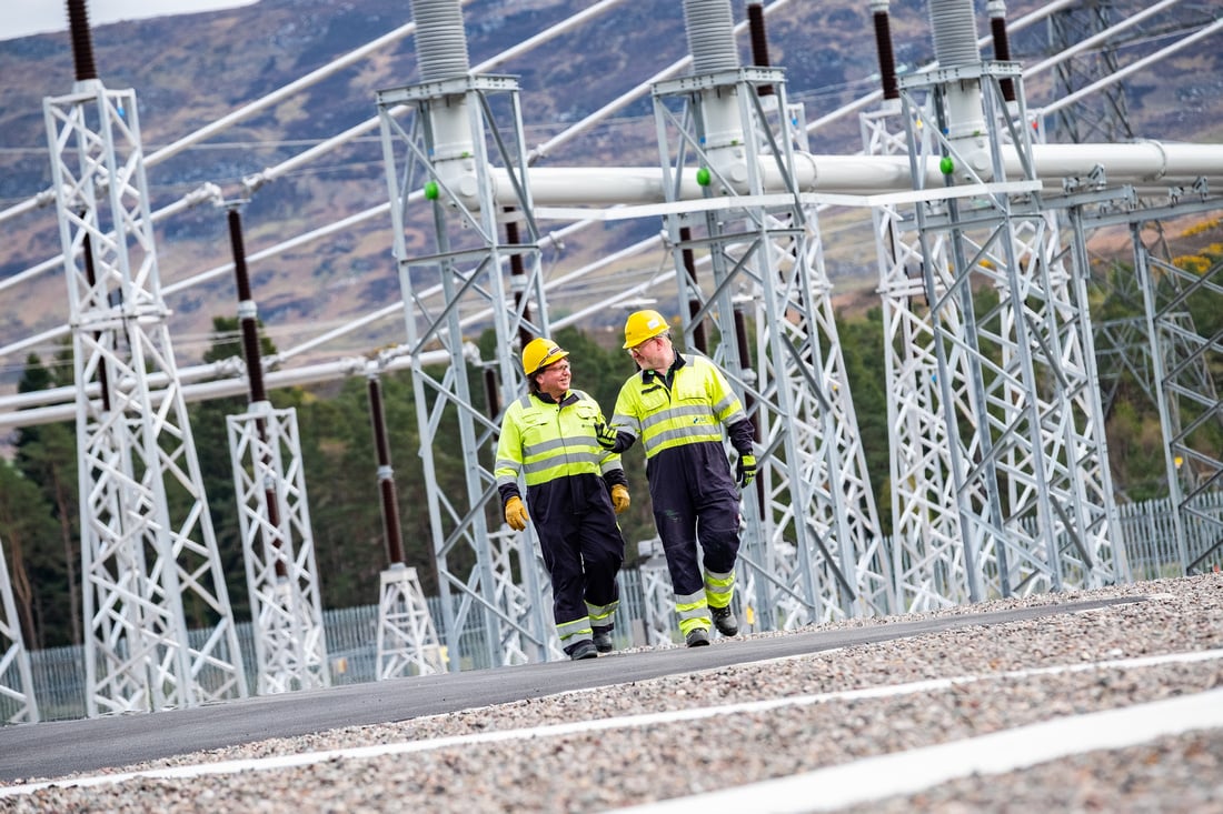 Two workers walking through site.