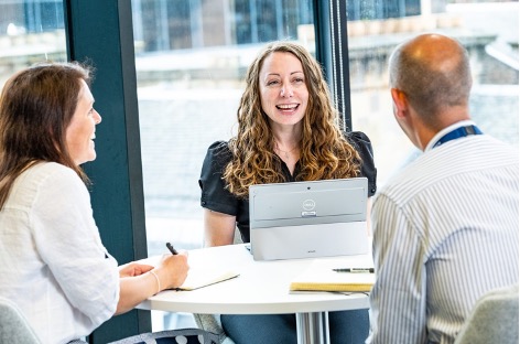 Christianna Logan, Director of Customers and Stakeholders, meets with two other people at a round table.