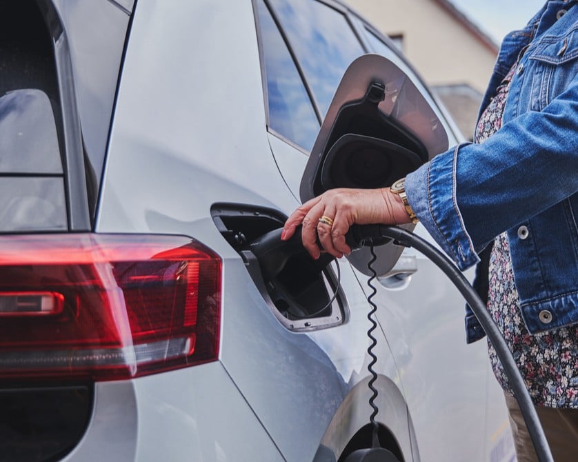 A woman charging her electric car