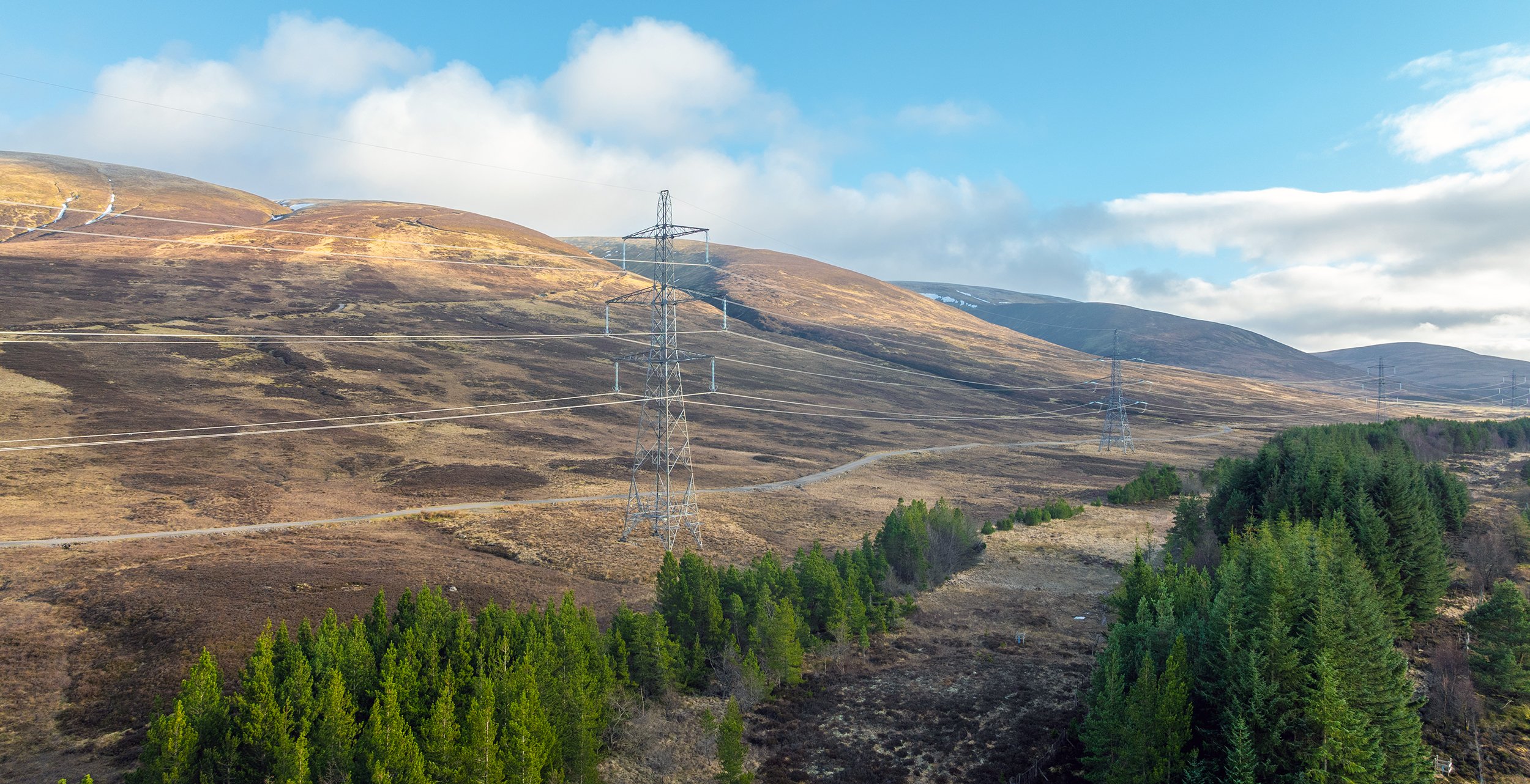 Image shows a pylon against a background of hills and countryside