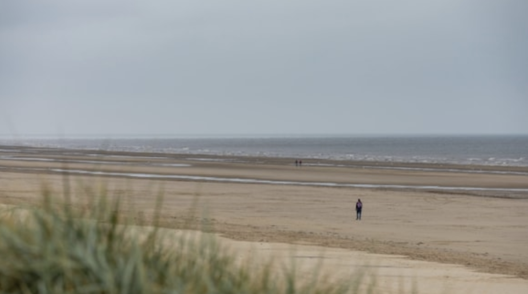 Person walking on a beach.png