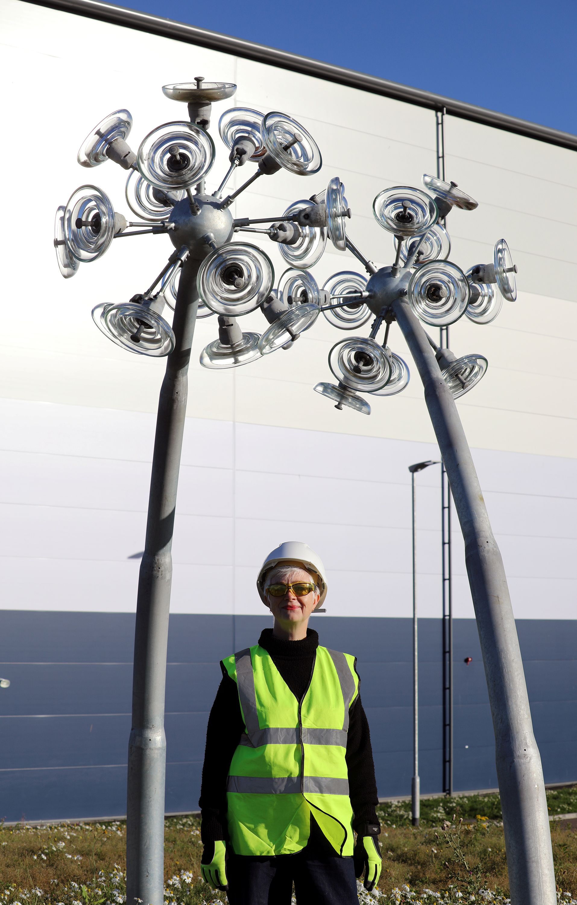 Artist Ailsa Magnus with her dandelion sculpture using reclaimed glass insulators from the transmission network
