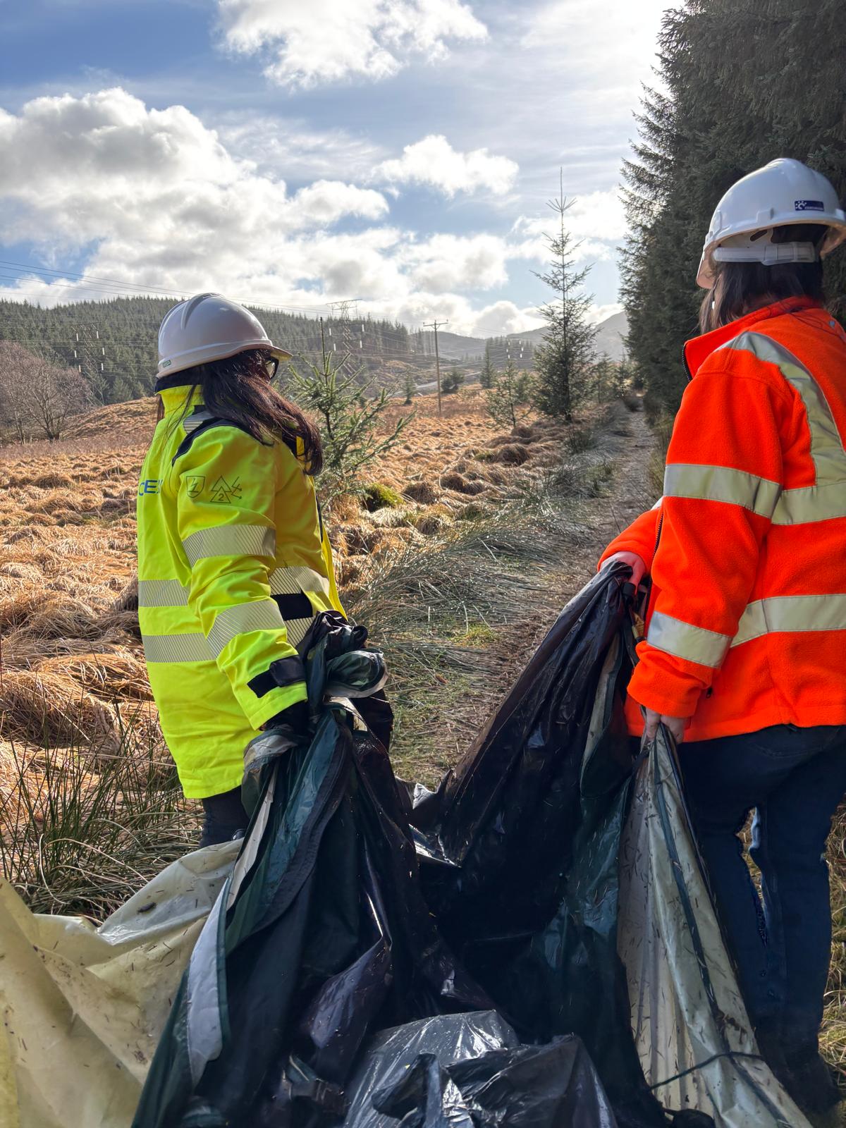 Volunteers work to remove discarded camping equipment from the Three Lochs Way