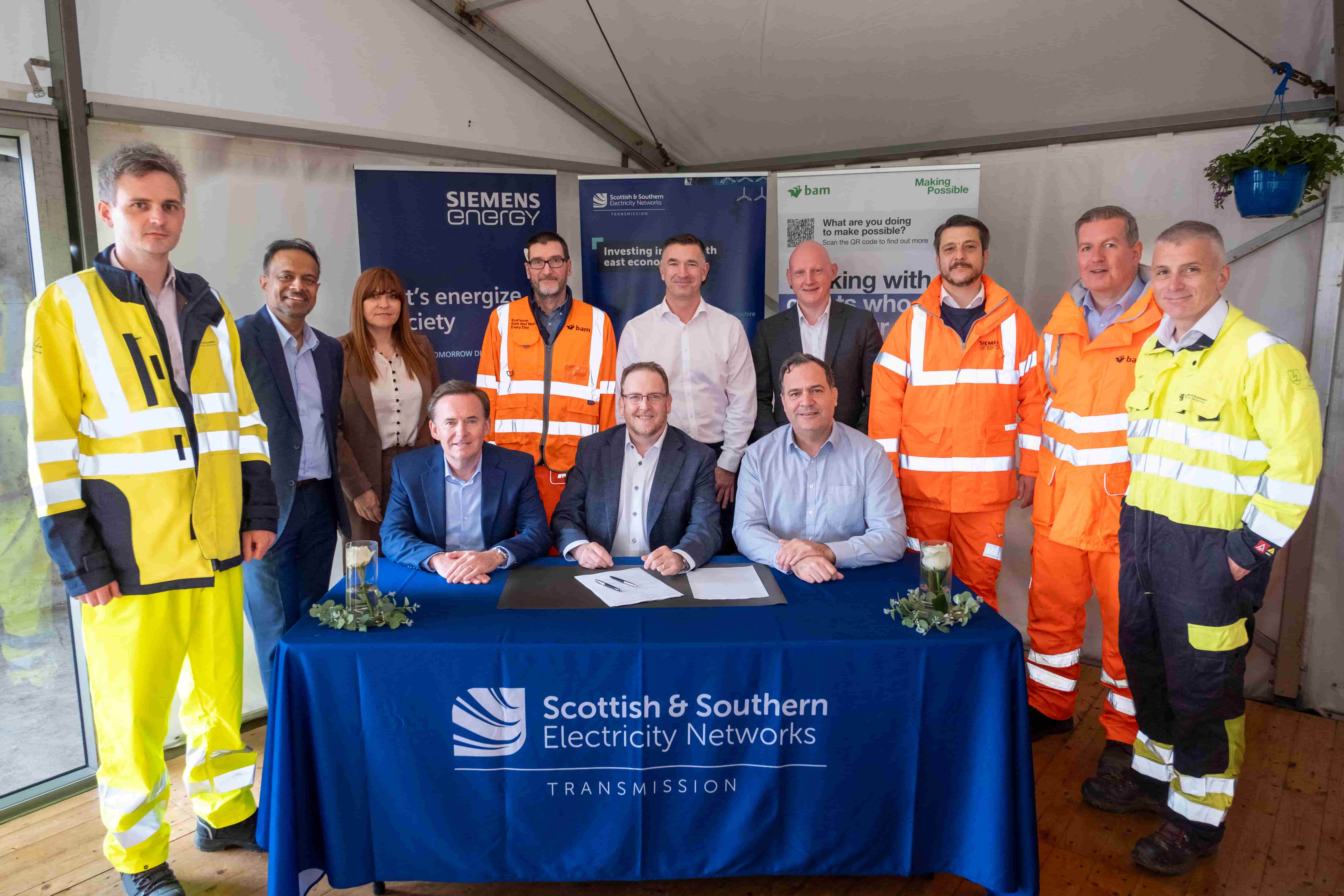 Teams from Siemens, BAM and SSEN Transmission gather around the table at contract signing event.